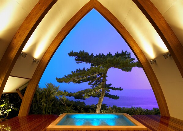 A spa area with a wooden arch and a view of the ocean. - Shimoda Yamatokan (Shimoda)
