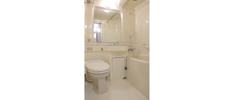 Une petite salle de bain compacte, équipée de toilettes, d’un lavabo et d’une baignoire.