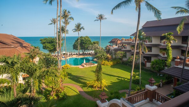 A resort with a pool, palm trees, and a view of the ocean. - Aloha Resort (Koh Samui)