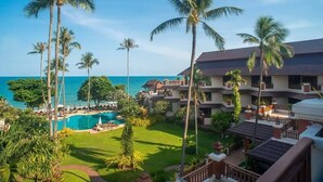 A resort with a pool, palm trees, and a view of the ocean. - Aloha Resort (Koh Samui)