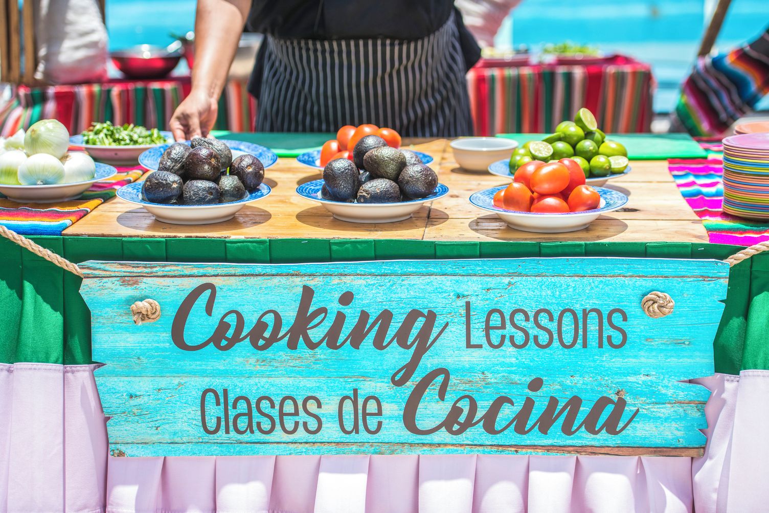 A table with various food items and a sign that reads 'Cooking Lessons Clases de Cocina'.