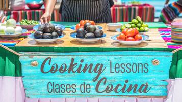 A table with various food items and a sign that reads 'Cooking Lessons Clases de Cocina'.