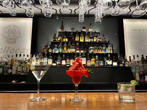A bar area with a variety of liquor bottles and two unique cocktails. - Hotel GS Quinto Sol (Teotihuacan)