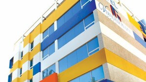 A multi-story hotel with a colorful facade, featuring a prominent 'HOTEL' sign at the top.