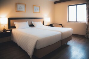 A double bed with a wooden headboard, two bedside tables with lamps, a chair, and a window with curtains. - Hotel D. Luís (Coimbra)