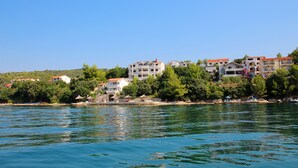 Ein Hotel an der Küste mit mehreren Etagen, Balkonen und direkter Strandlage.