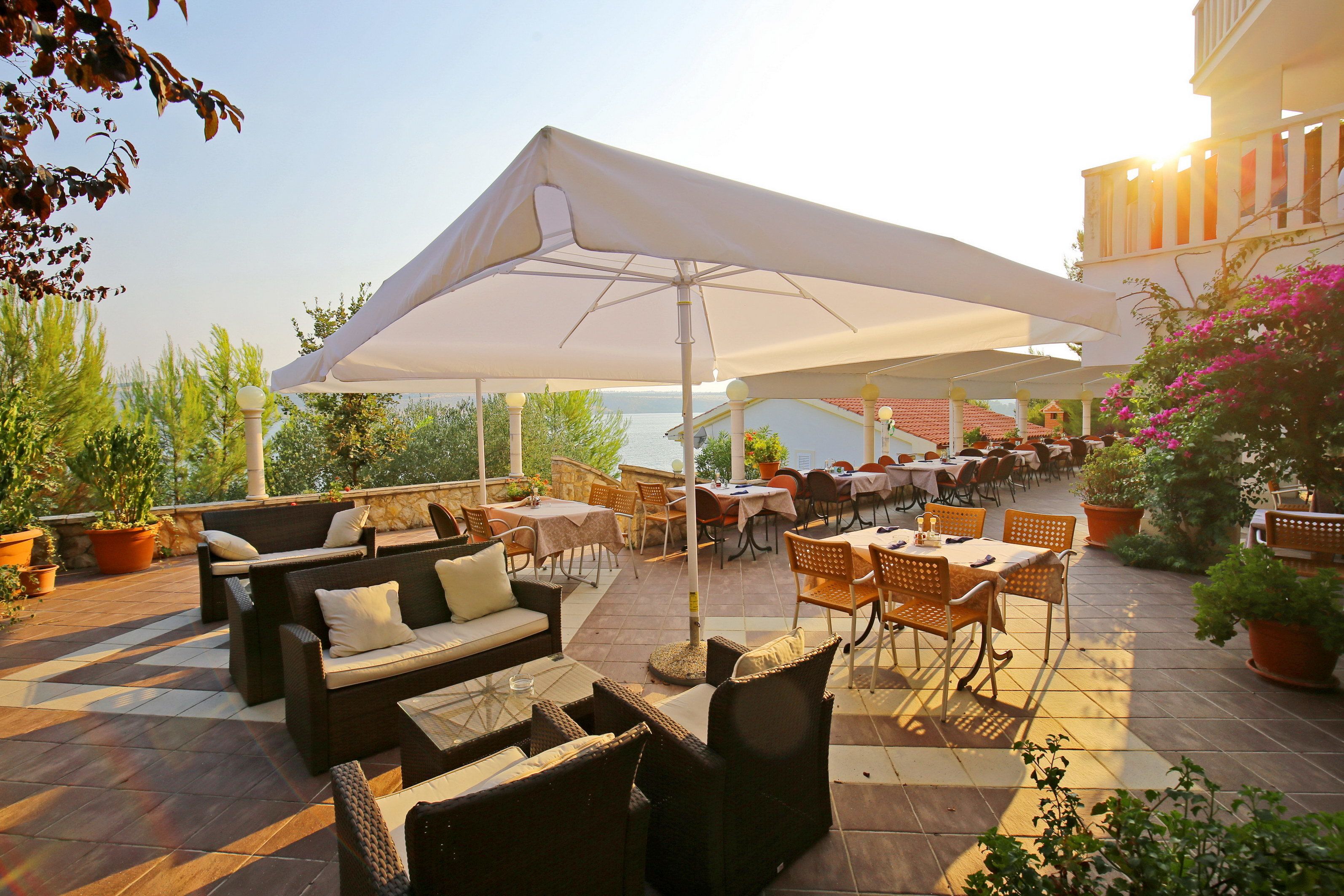 An outdoor patio with seating, tables, and umbrellas.
