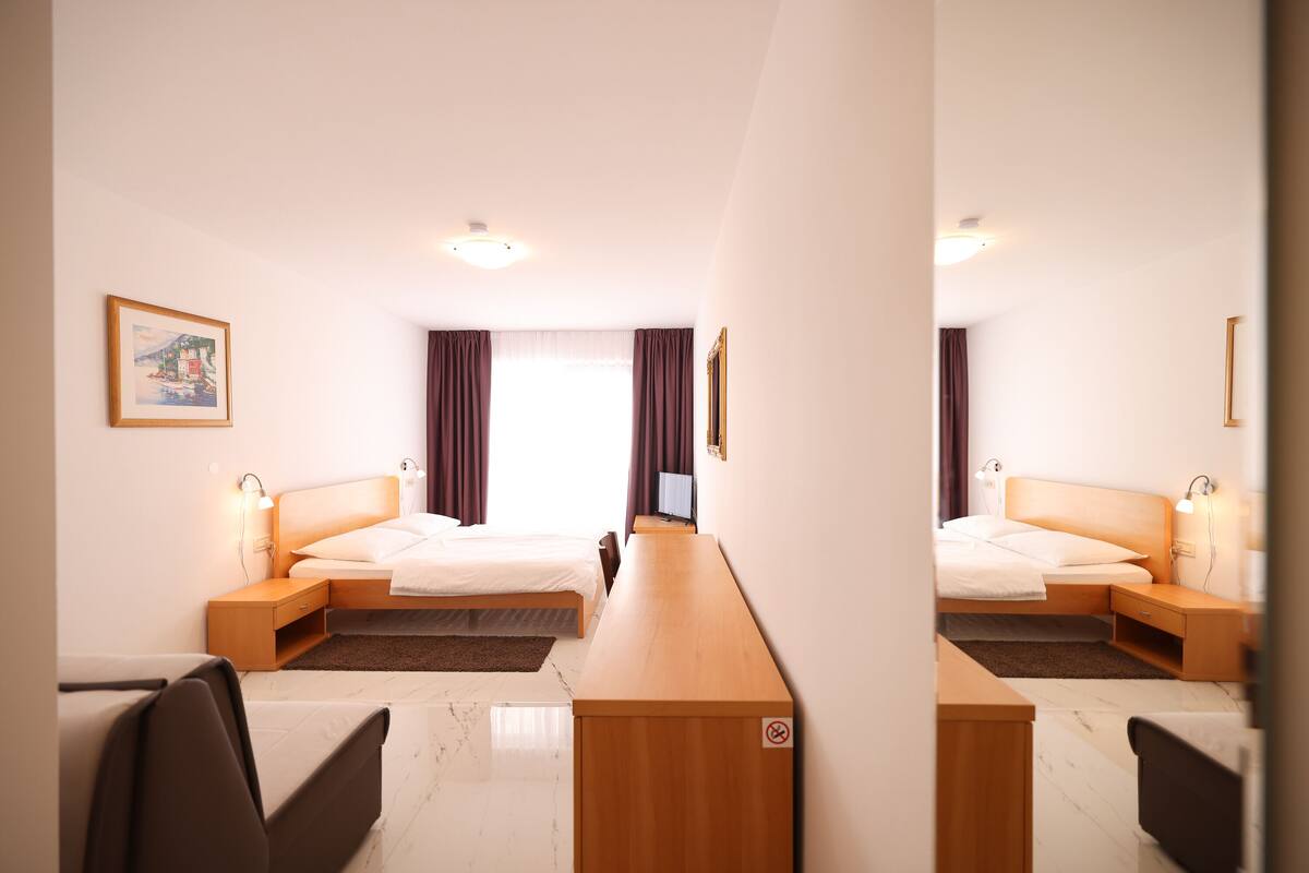 Una habitación de hotel con dos camas, un escritorio y una silla.
