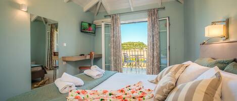 Et hotelværelse med seng, badeværelse, fjernsyn og balkon med udsigt.