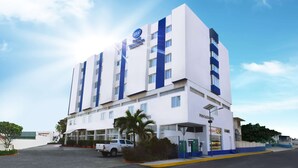 A multi-story hotel with a prominent 'BW Best Western' sign, a restaurant, and a parking area with a white pickup truck. - Best Western Global Express (Veracruz)
