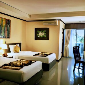 A hotel room with two beds, a dining area, and a view of the outdoors. - Royal Peninsula Hotel Chiang Mai (Chiang Mai)