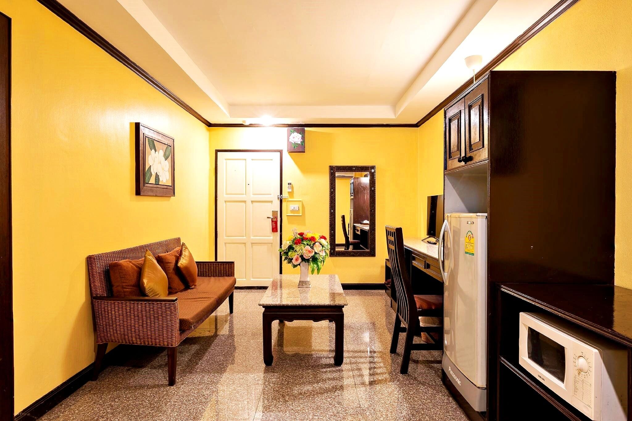 A compact kitchen with a refrigerator, microwave, and dining area with a table and chairs.
