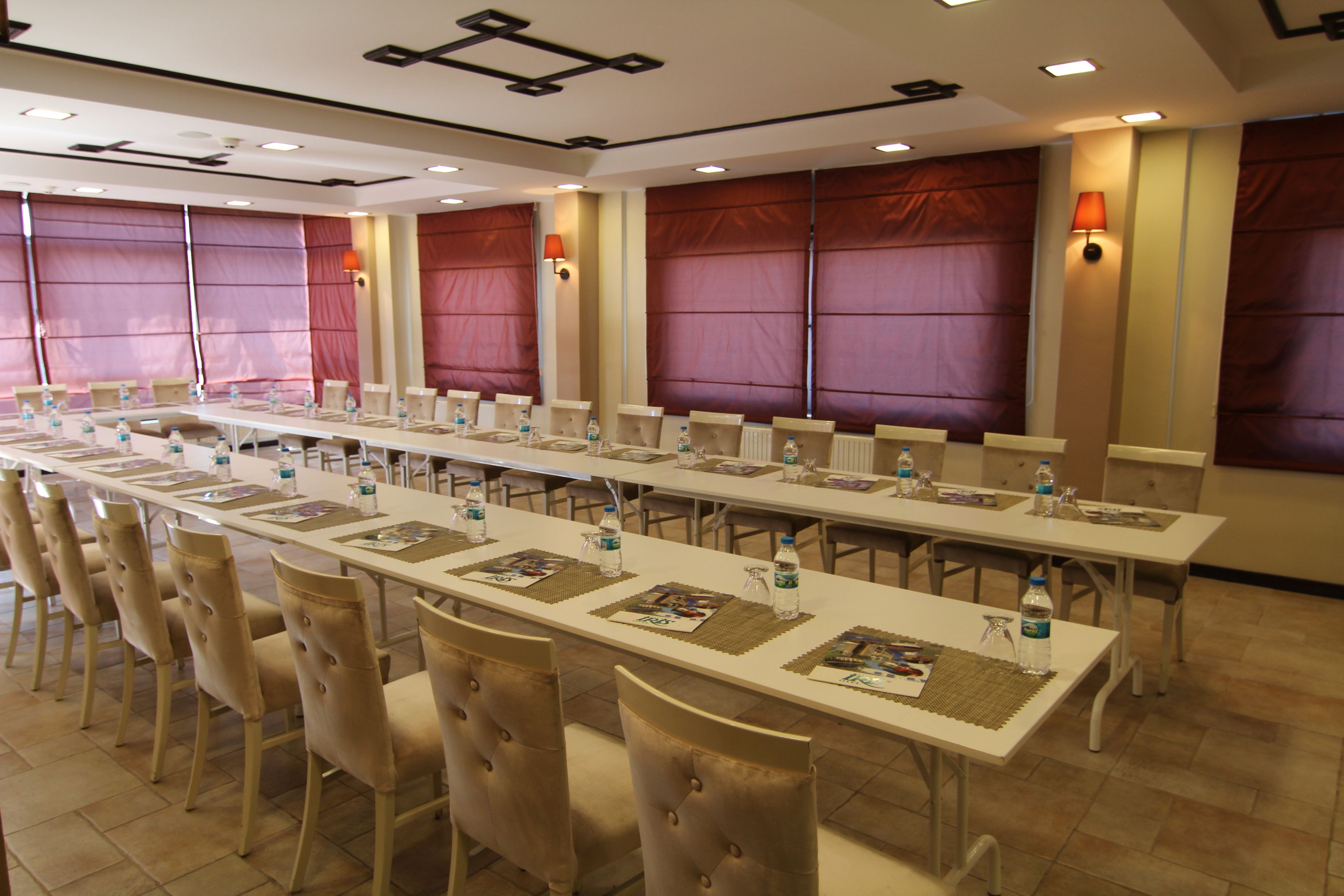 A conference room with long tables, chairs, and water bottles.