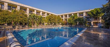Una piscina al aire libre de temporada, sillones reclinables de piscina