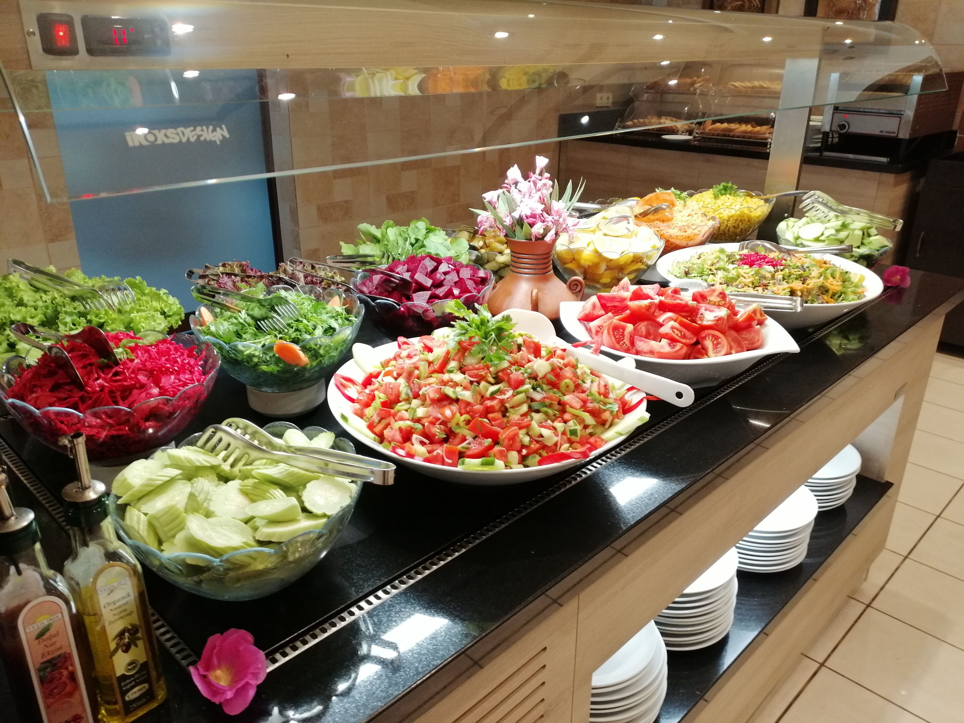 Een buffet met diverse salades, fruit en groenten.