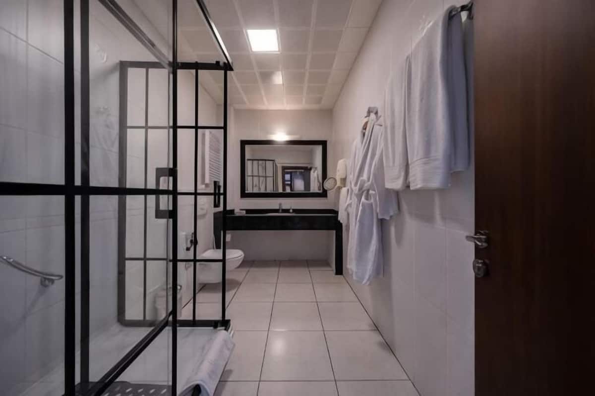 Ein Badezimmer mit Glasdusche, Toilette, Waschbecken und Spiegel.