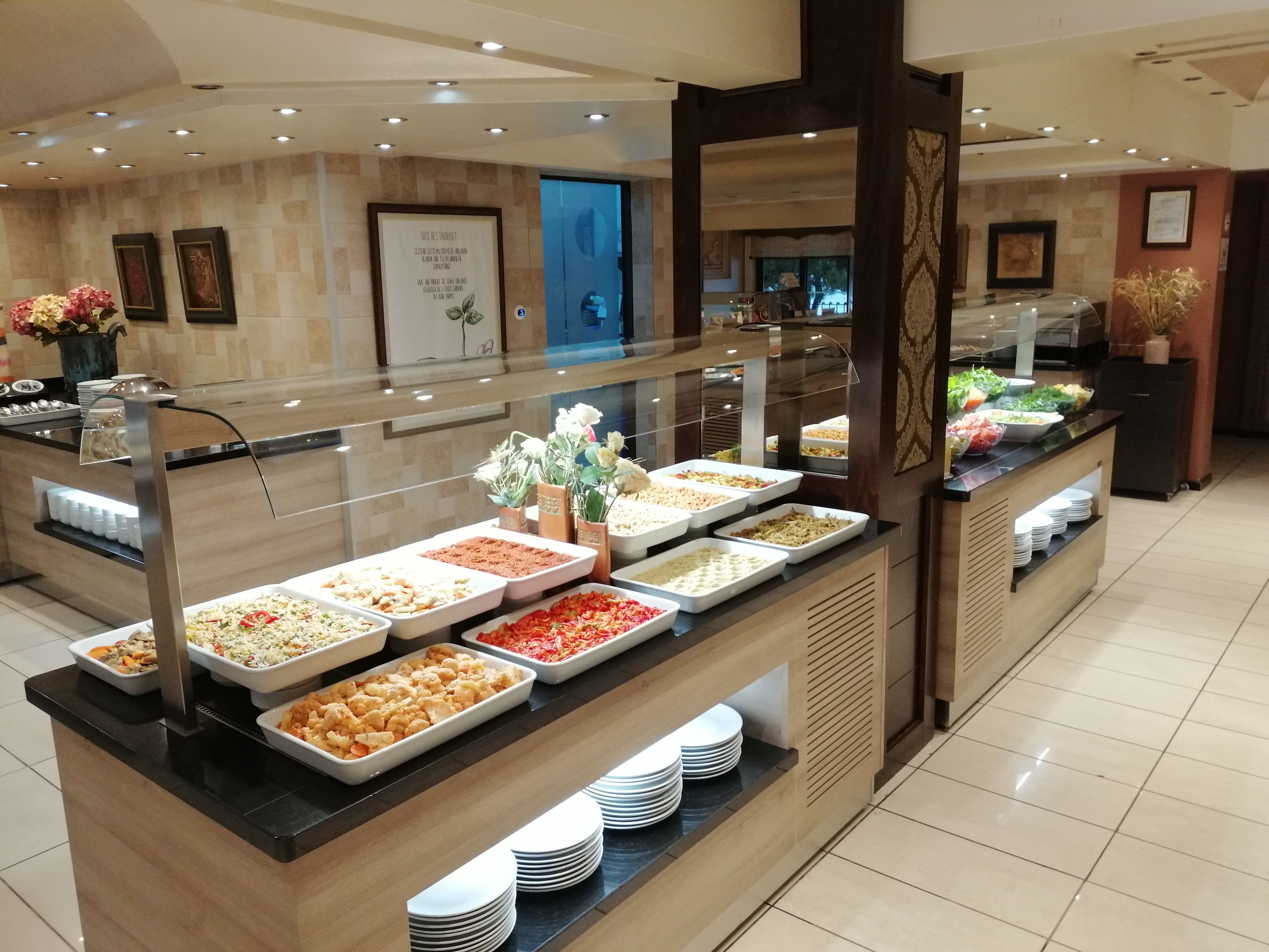 Zona de buffet amb diversos plats i una vitrina de cristall.