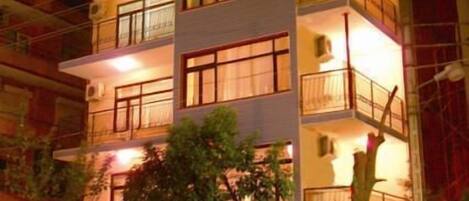 Un hôtel à plusieurs étages doté de balcons, d’un espace extérieur aménagé pour s’asseoir et d’un restaurant.