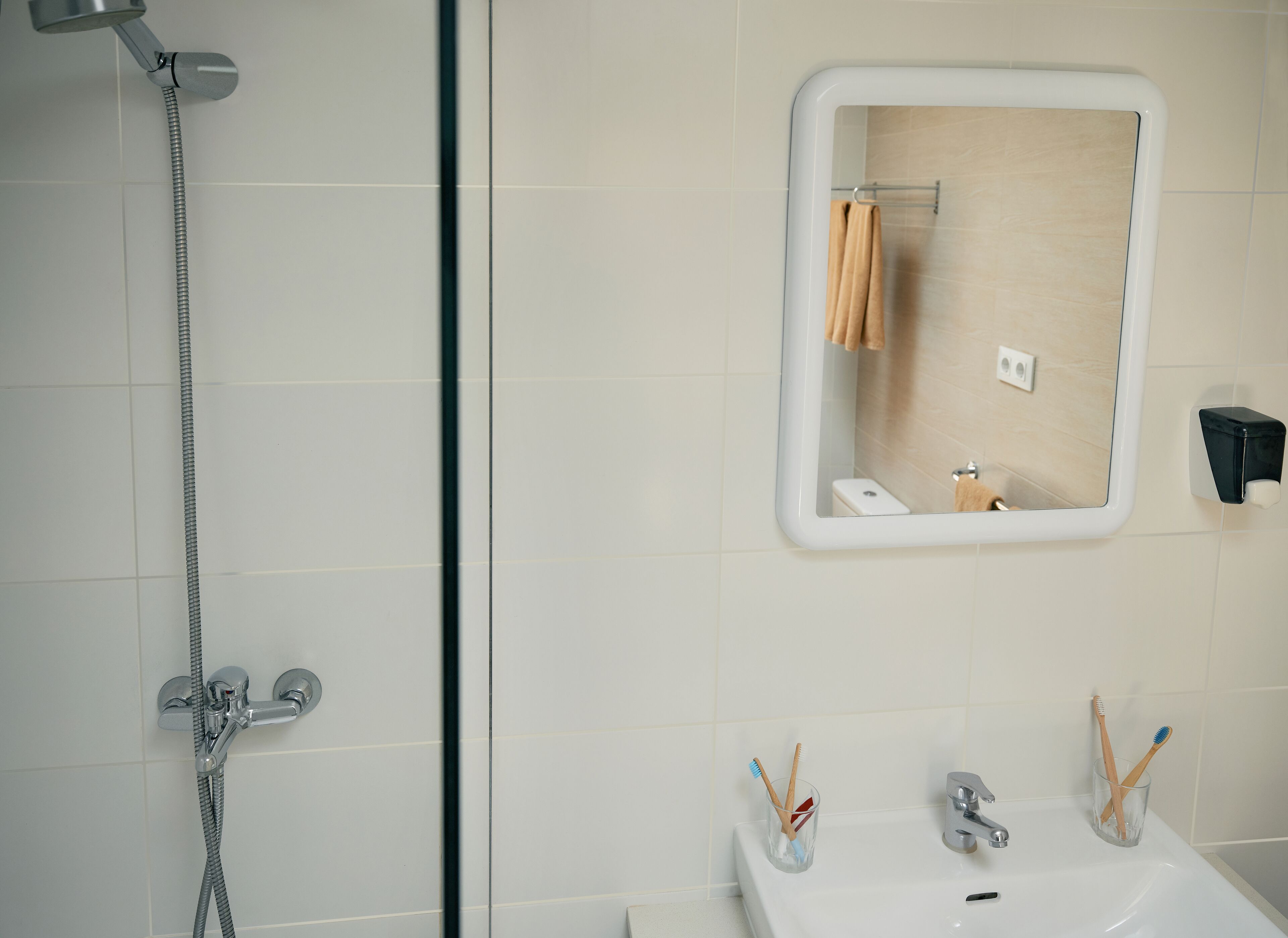 A bathroom with a shower, sink, and mirror.