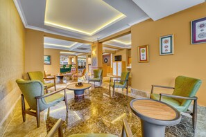 A spacious lobby with modern furniture, a marble floor, and a large wall clock. - Yeniacun Apart Hotel (Alanya)