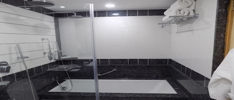 Un bagno moderno con doccia vetrata, una vasca freestanding e un portasciugamani.