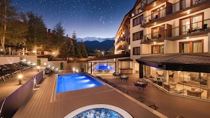 Un hôtel doté d'une piscine, d'un espace extérieur aménagé et offrant une vue sur les montagnes.