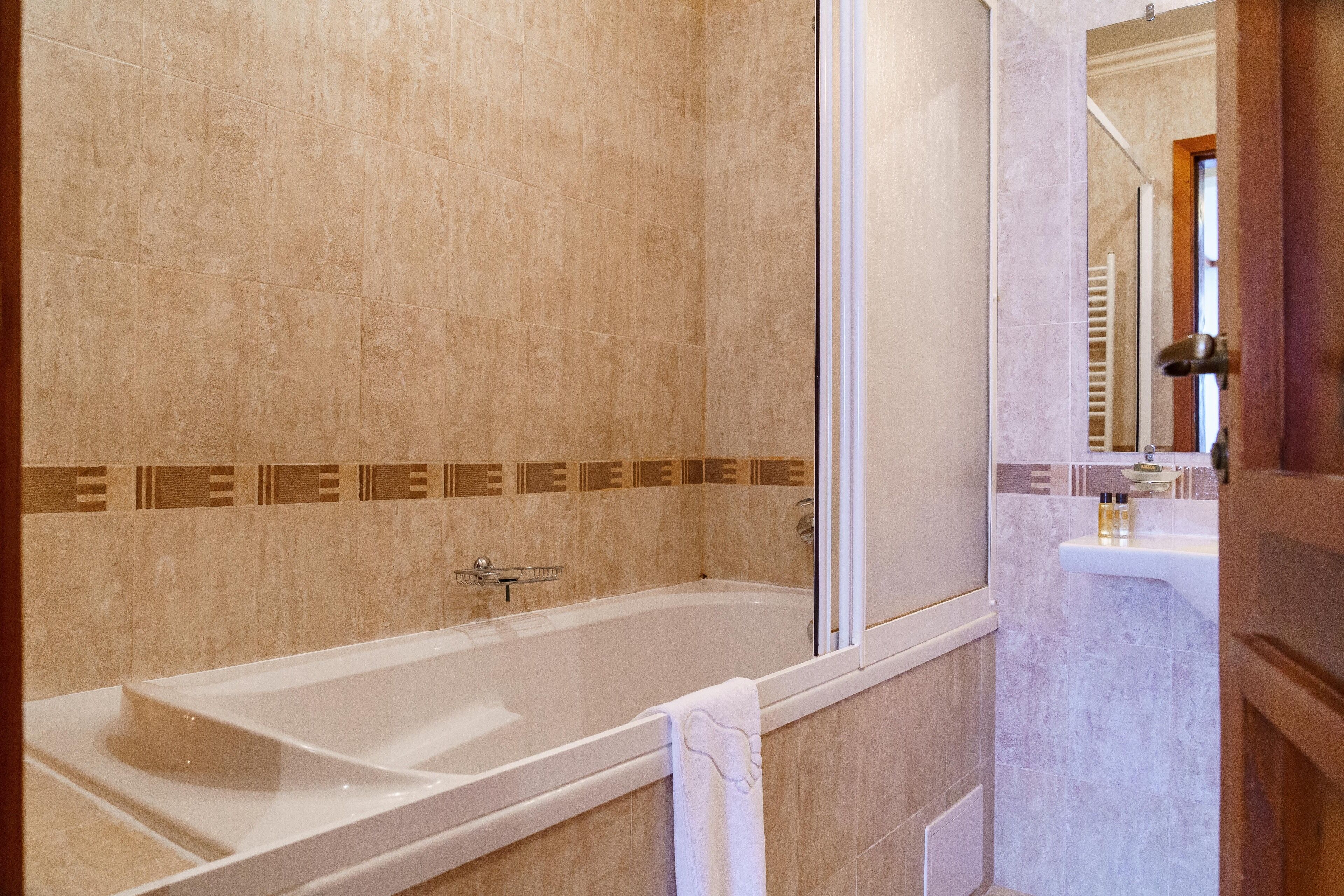Un baño con bañera, ducha y lavabo.