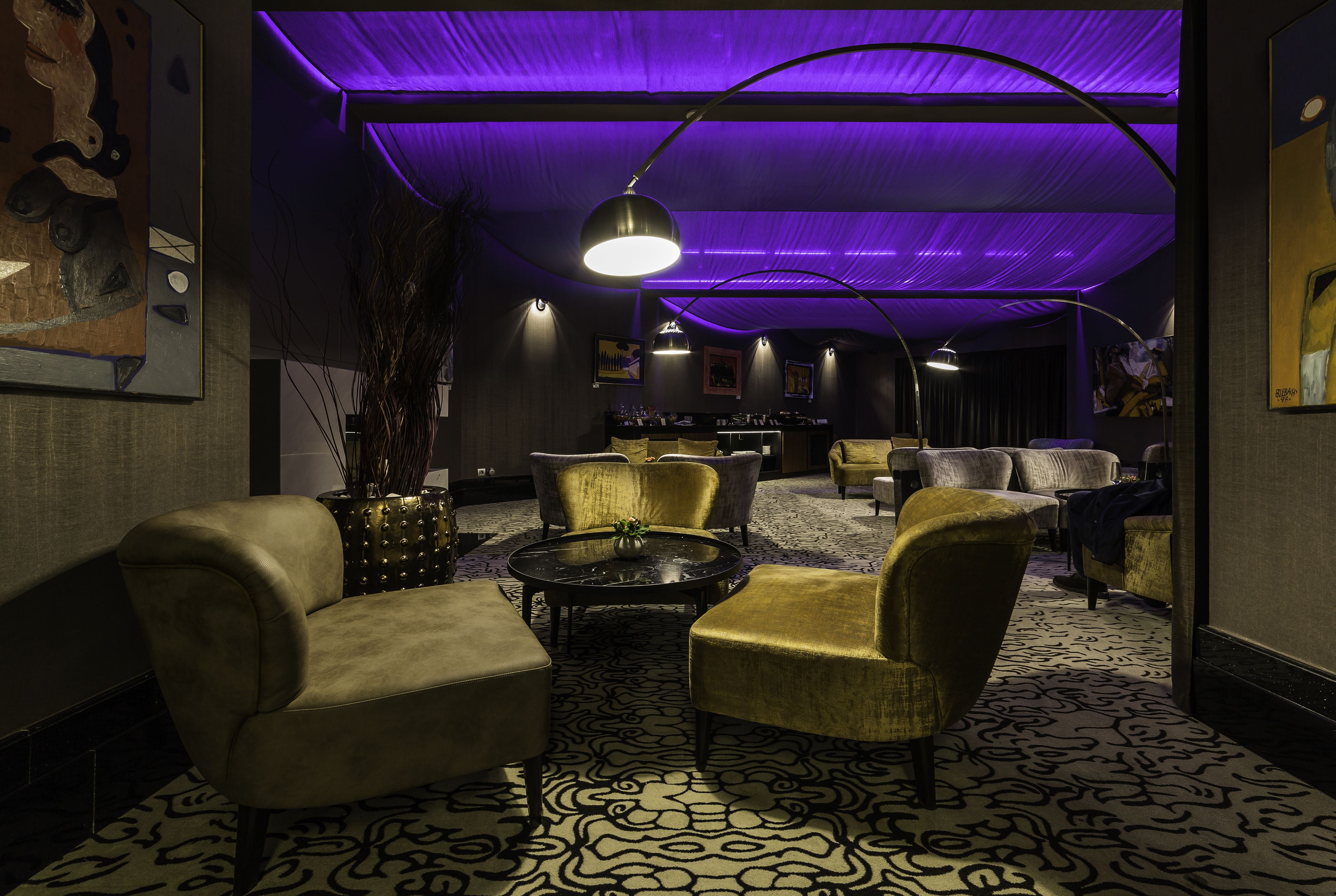 A lounge area with sofas and armchairs, a round coffee table, and a patterned carpet.