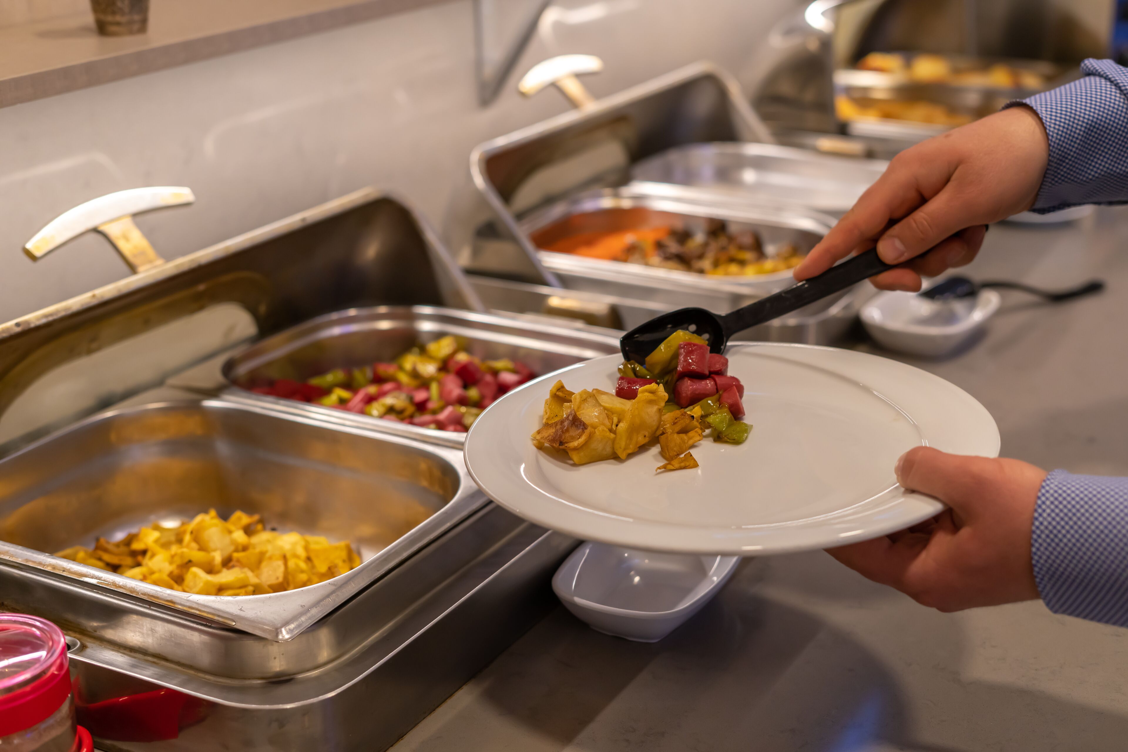 Un buffet avec différents plats présentés dans des récipients en métal.