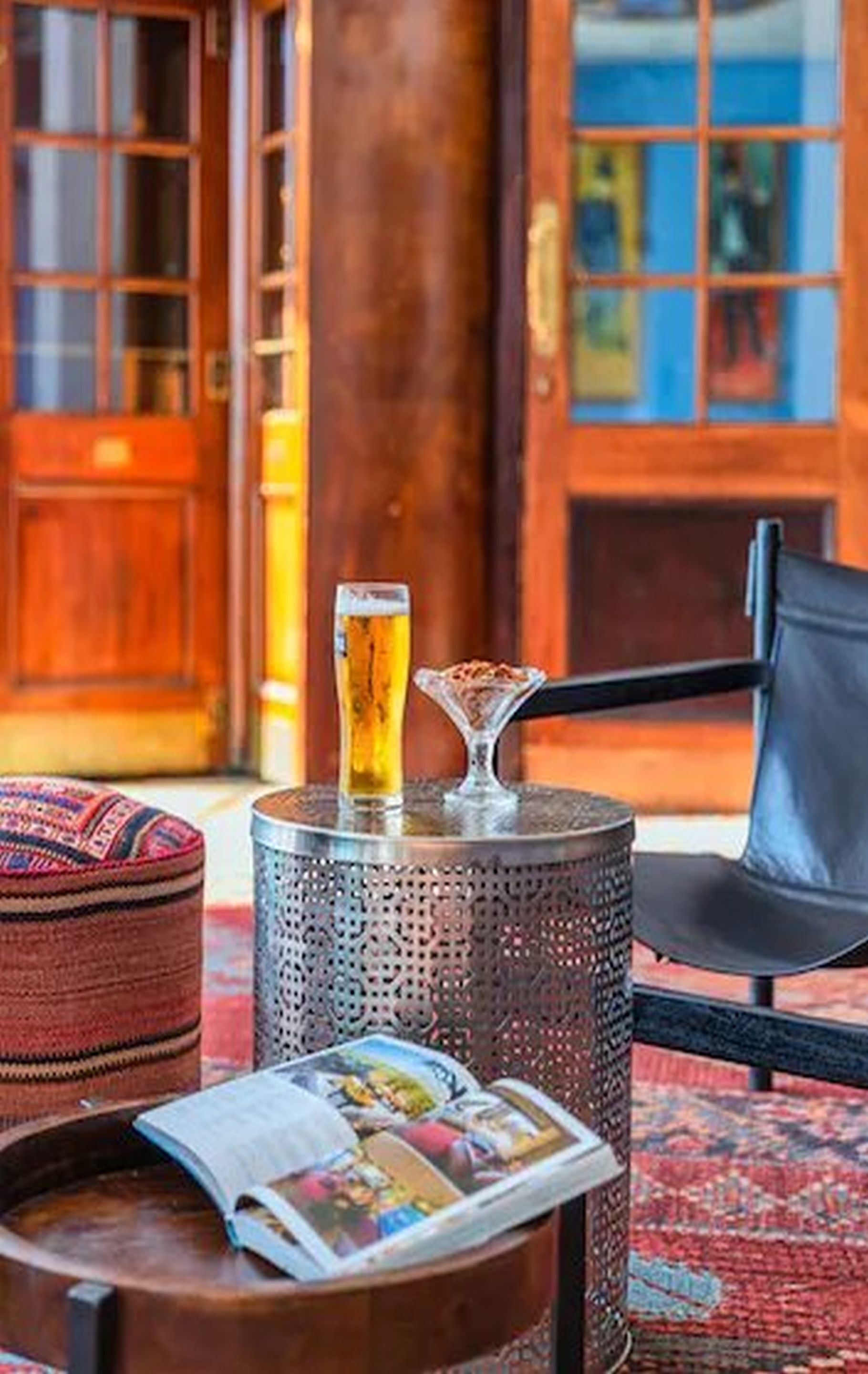 Un rincón acogedor con una mesa redonda, una cerveza en un vaso y una revista.