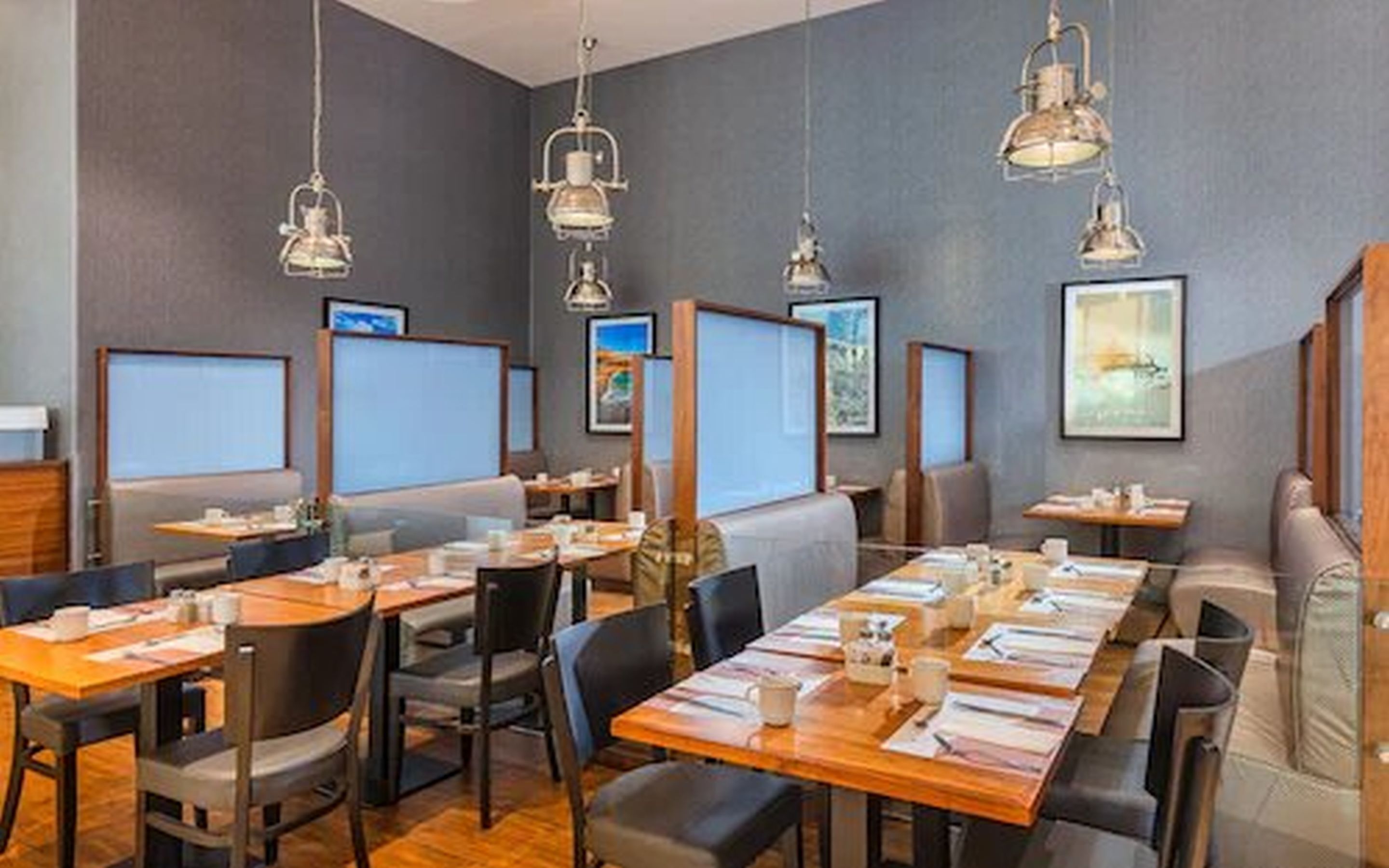 A conference room with multiple tables, chairs, and large screens.