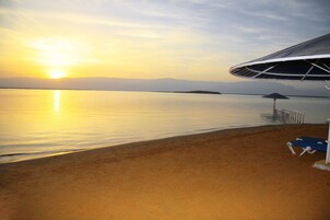 Playa privada, sillas reclinables de playa, sombrillas