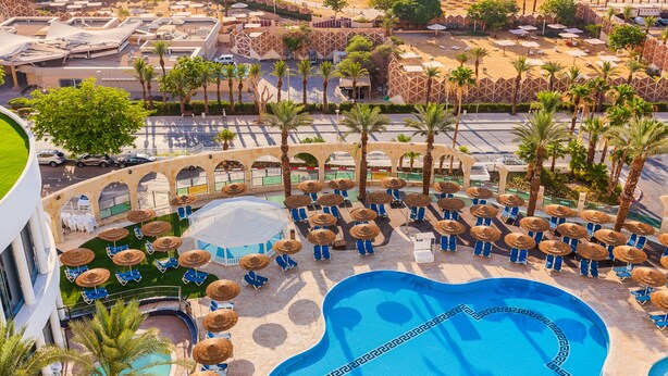 A resort with a large pool, sun loungers, and a beach area. - Brown Dead Sea by Brown Hotels (Tamar)