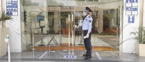 Un guardia de seguridad en la entrada de un edificio con un letrero que dice 'ENTRY'.