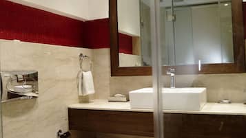 Un baño moderno con un espejo grande, un lavabo blanco y un inodoro.