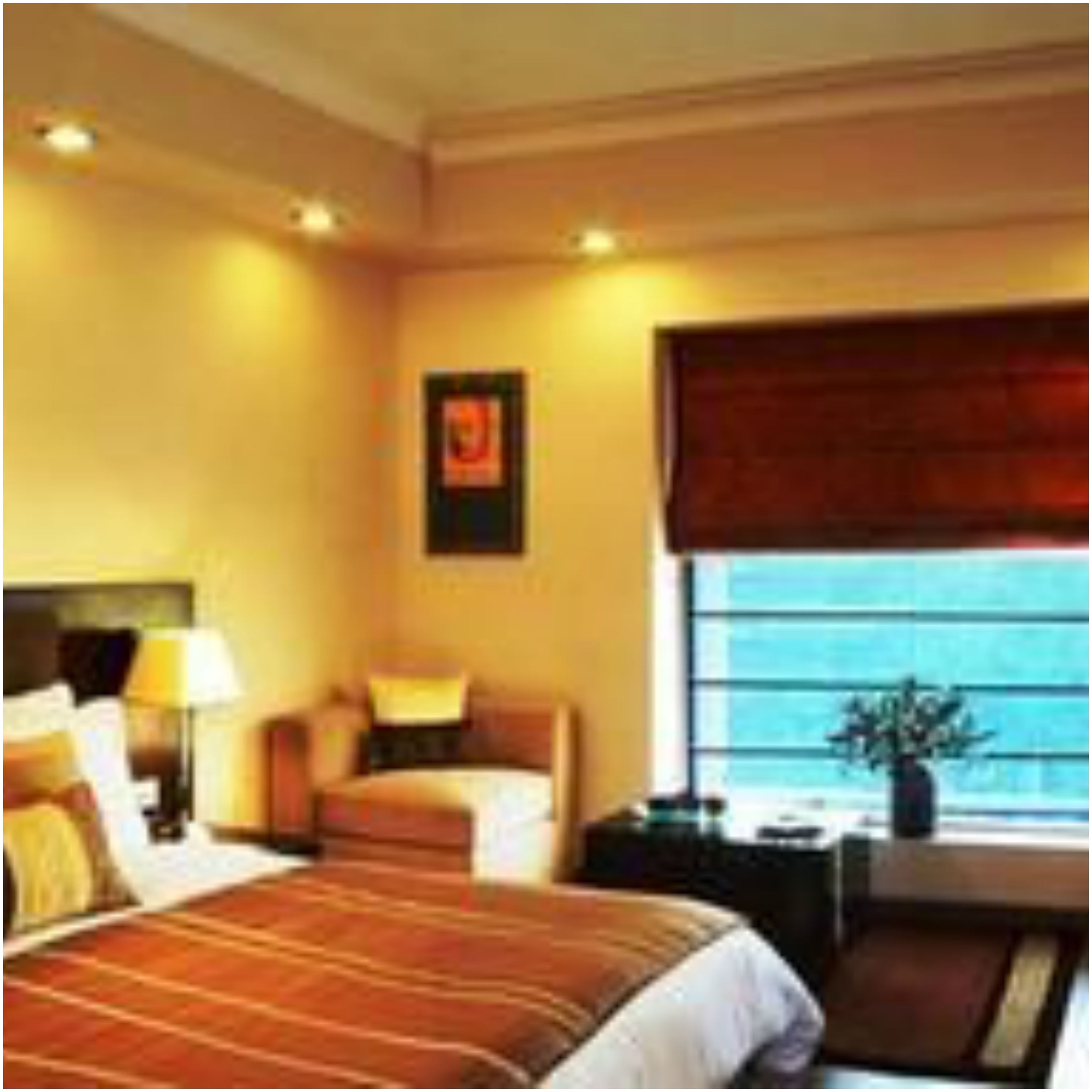 Quarto de hotel com uma cama grande, uma mesa de cabeceira, uma luminária, uma janela com vista e um quadro na parede.
