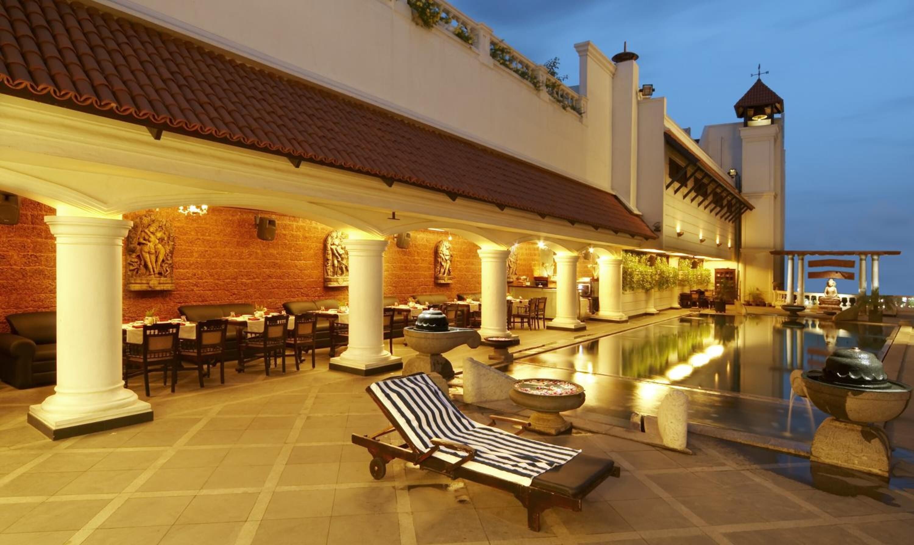 Ein Poolbereich auf dem Dach mit Liegestühlen und Essbereich mit Tischen und Stühlen.