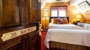 Egy szállodai szoba, amelyben található egy ágy, egy éjjeliszemélyzet, egy lámpa, egy kockás függönnyel ellátott ablak, és egy „20 MAE WEST” felirattal ellátott ajtó.