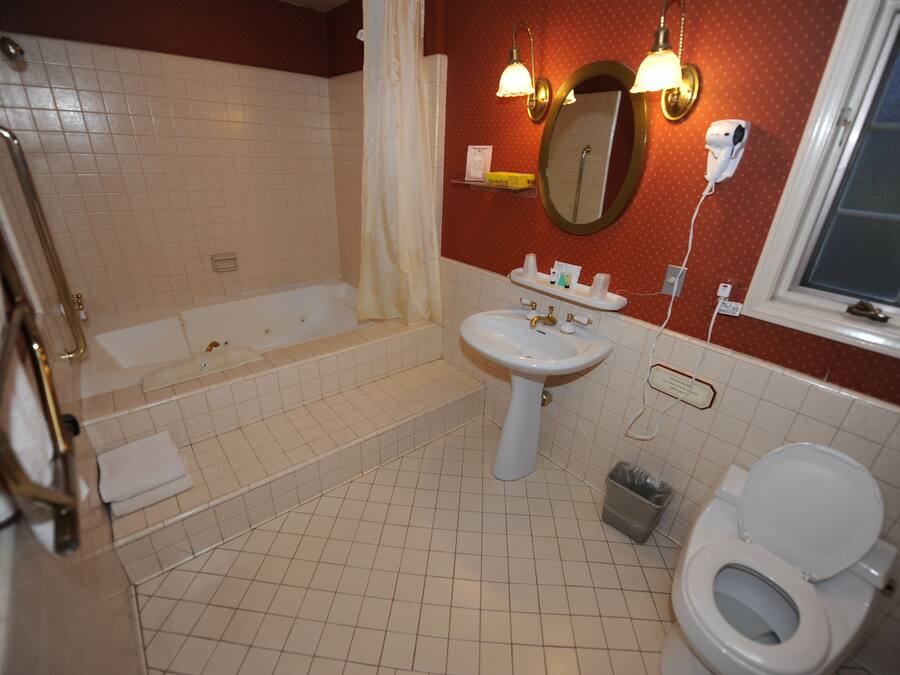Een badkamer met een bad, wastafel, toilet en douchegordijn.
