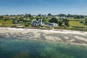 A coastal property with a large house, a beach, and surrounding greenery. - Résidence Odalys Domaine des Roches Jaune (Plougasnou)