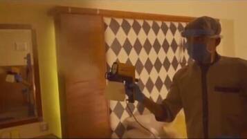 Una habitación con un espejo, una puerta y un papel tapiz estampado.