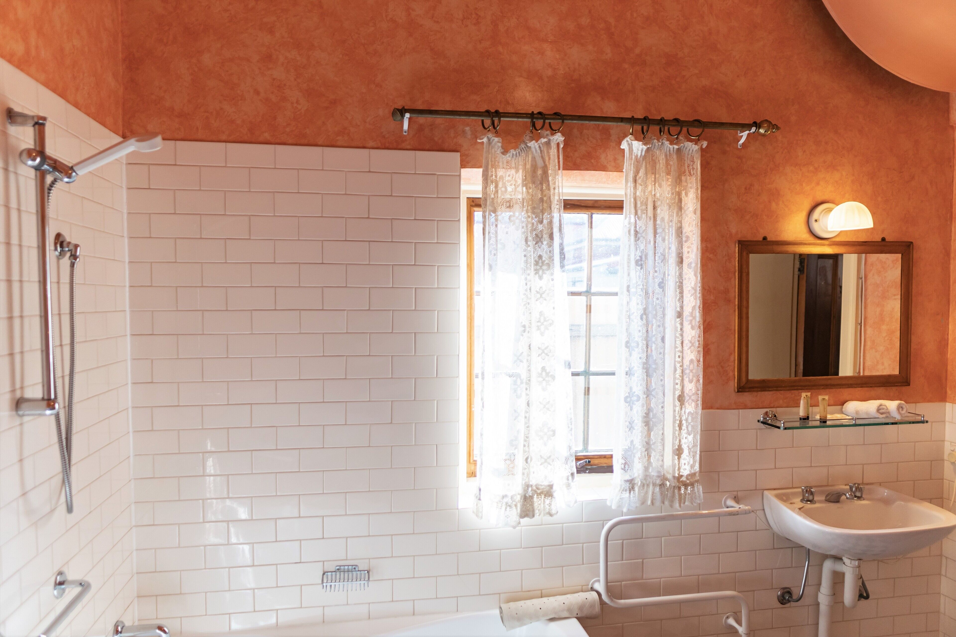 A bathroom with a shower, a sink, and a mirror.