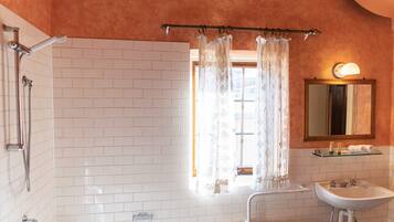 A bathroom with a shower, a sink, and a mirror.