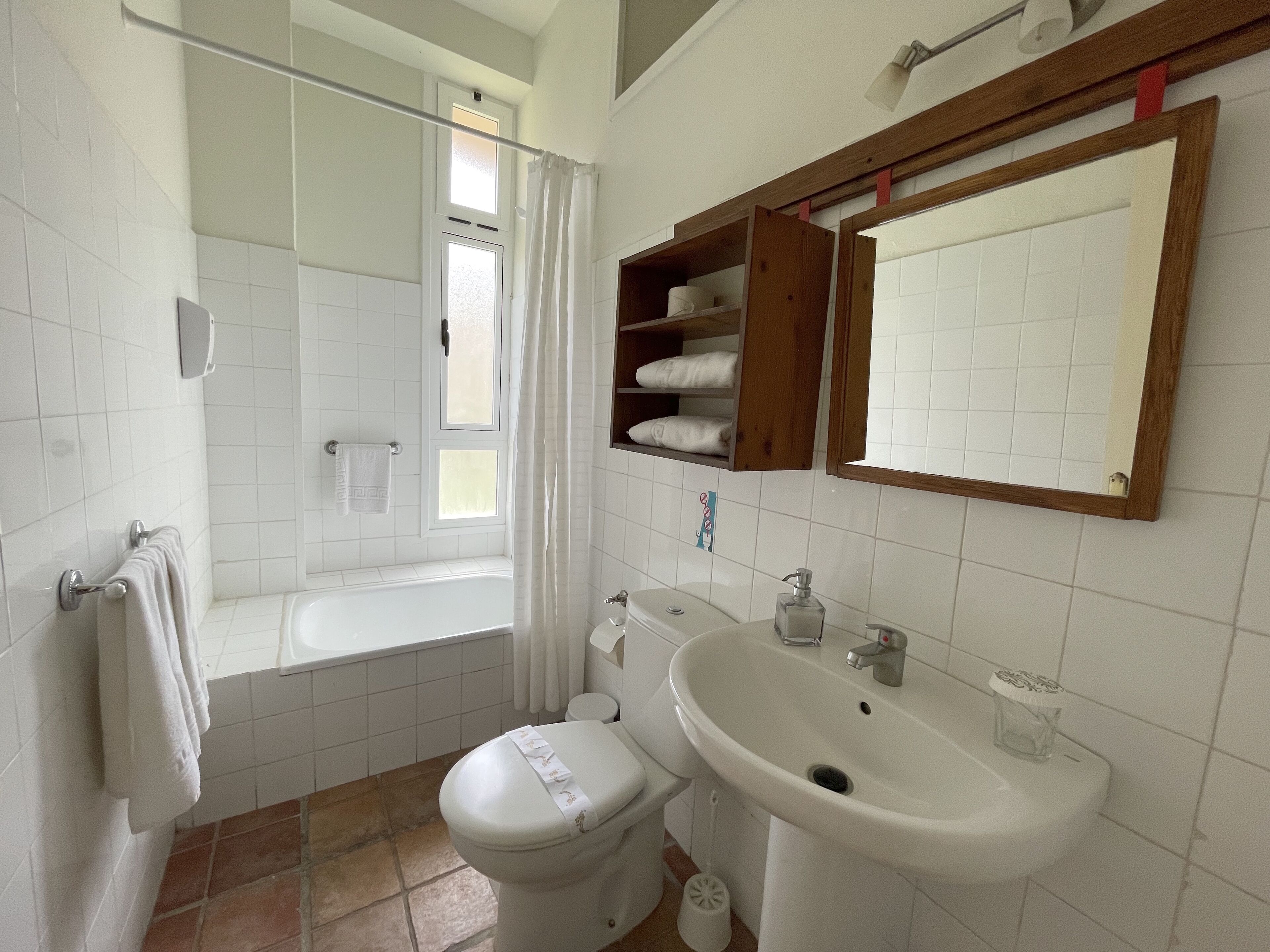 Un baño con bañera, inodoro, lavabo y espejo.