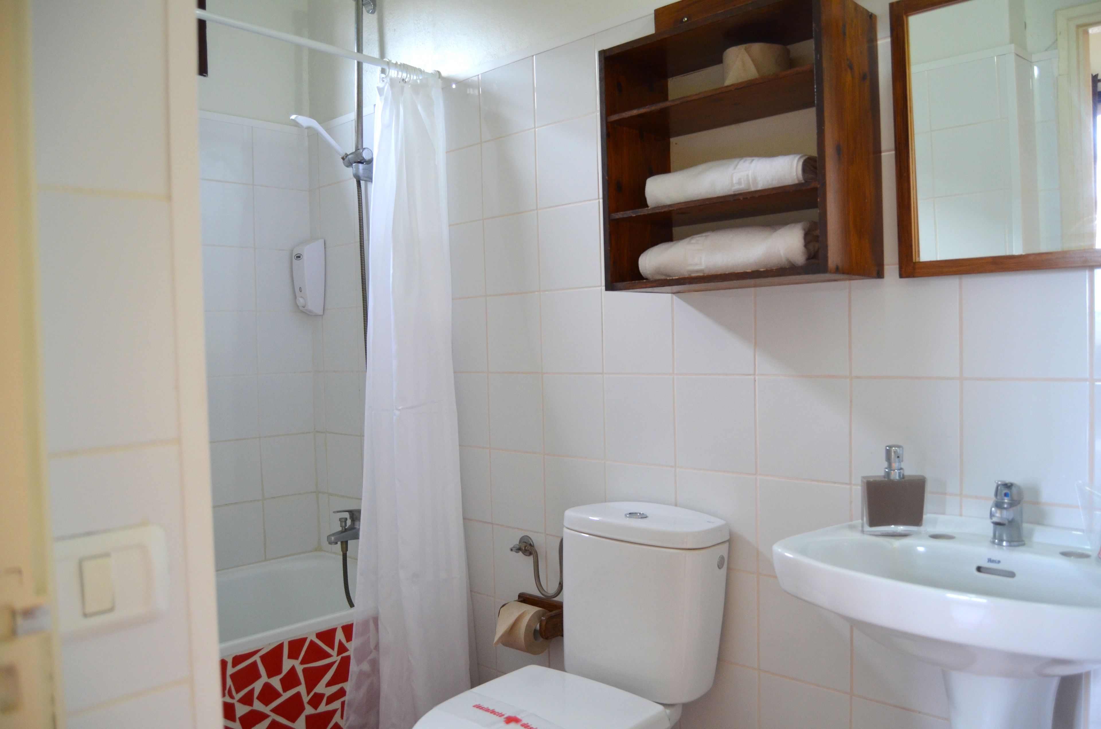 A bathroom with a shower, toilet, and sink.