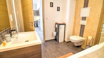 Une petite salle de bain comprenant un lavabo, des toilettes et un espace douche.
