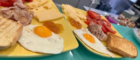 A breakfast plate with eggs, bacon, cheese, and toast.
