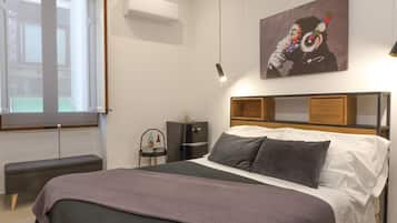Une chambre à coucher moderne avec un lit, un banc et une œuvre d’art.