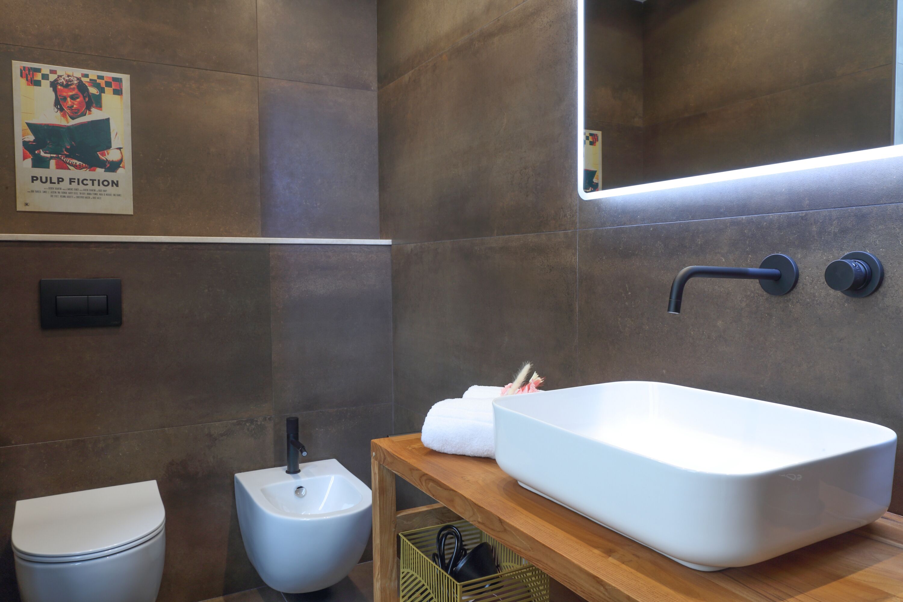 Ein modernes Badezimmer mit einem großen weißen Waschbecken, einem Bidet und einer Toilette.