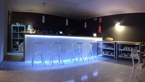 A modern bar area with a white bar counter, bar stools, and a shelf with bottles. - Farsund (Sanxenxo)